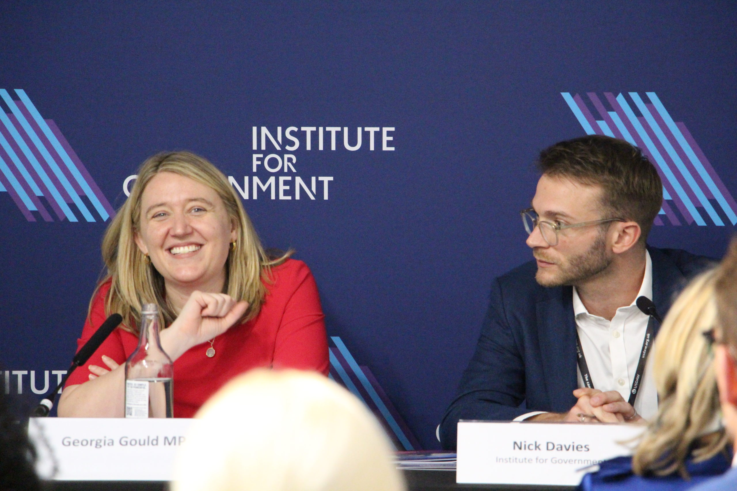 A panel discussion with Georgia Gould MP, smiling and speaking, and Nick Davies from the Institute for Government looking on.