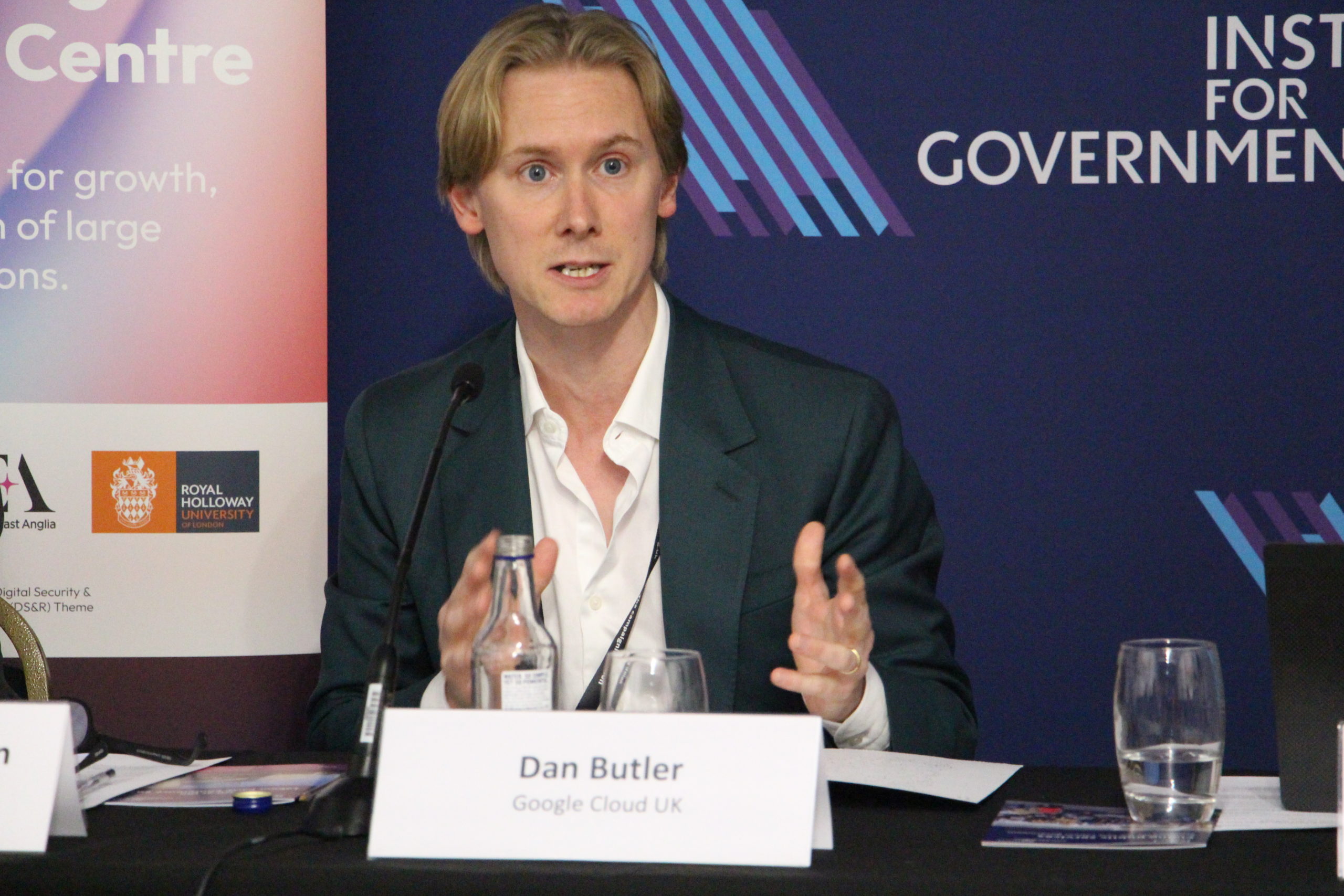 Dan Butler from Google Cloud UK speaking while Prof. Mark Thompson listens during the event.